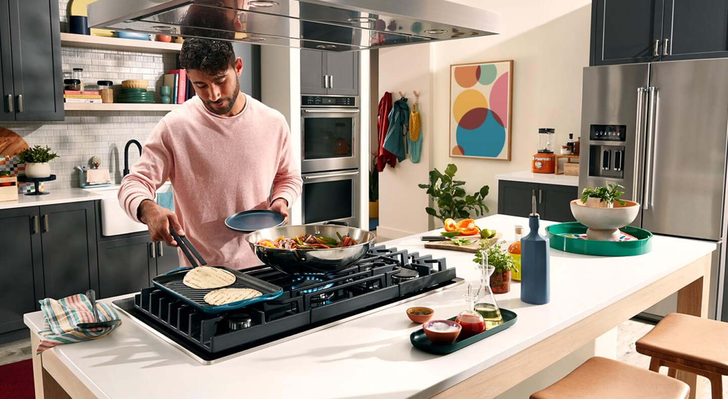 Person cooking on the griddle attachment of a gas stovetop