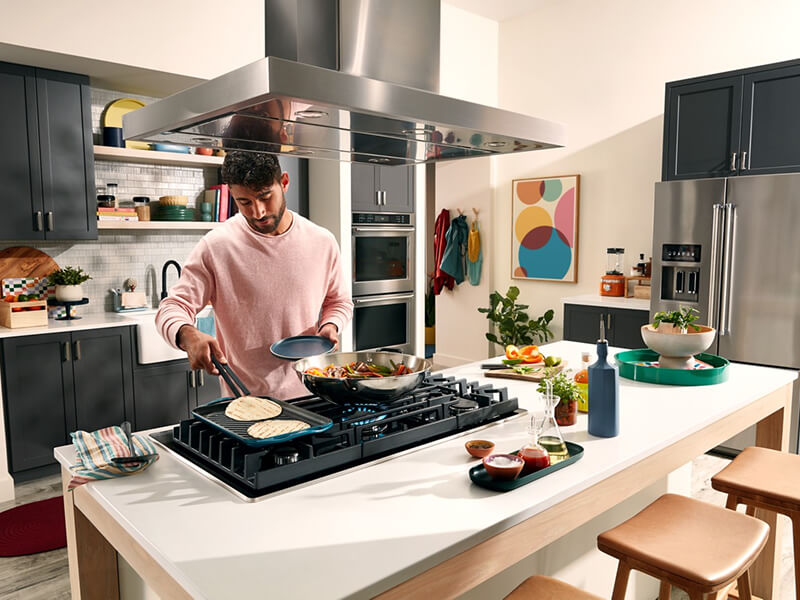 Person cooking on the griddle attachment of a gas stovetop