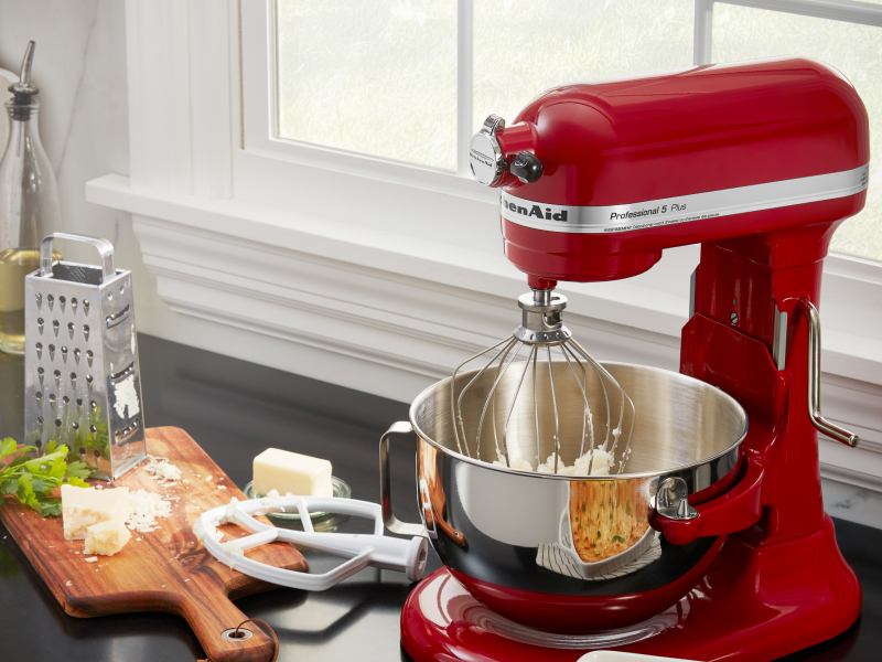 Red KitchenAid® stand mixer next to grated cheese and butter