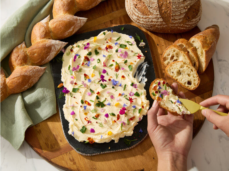 A person spreading butter on crostini.