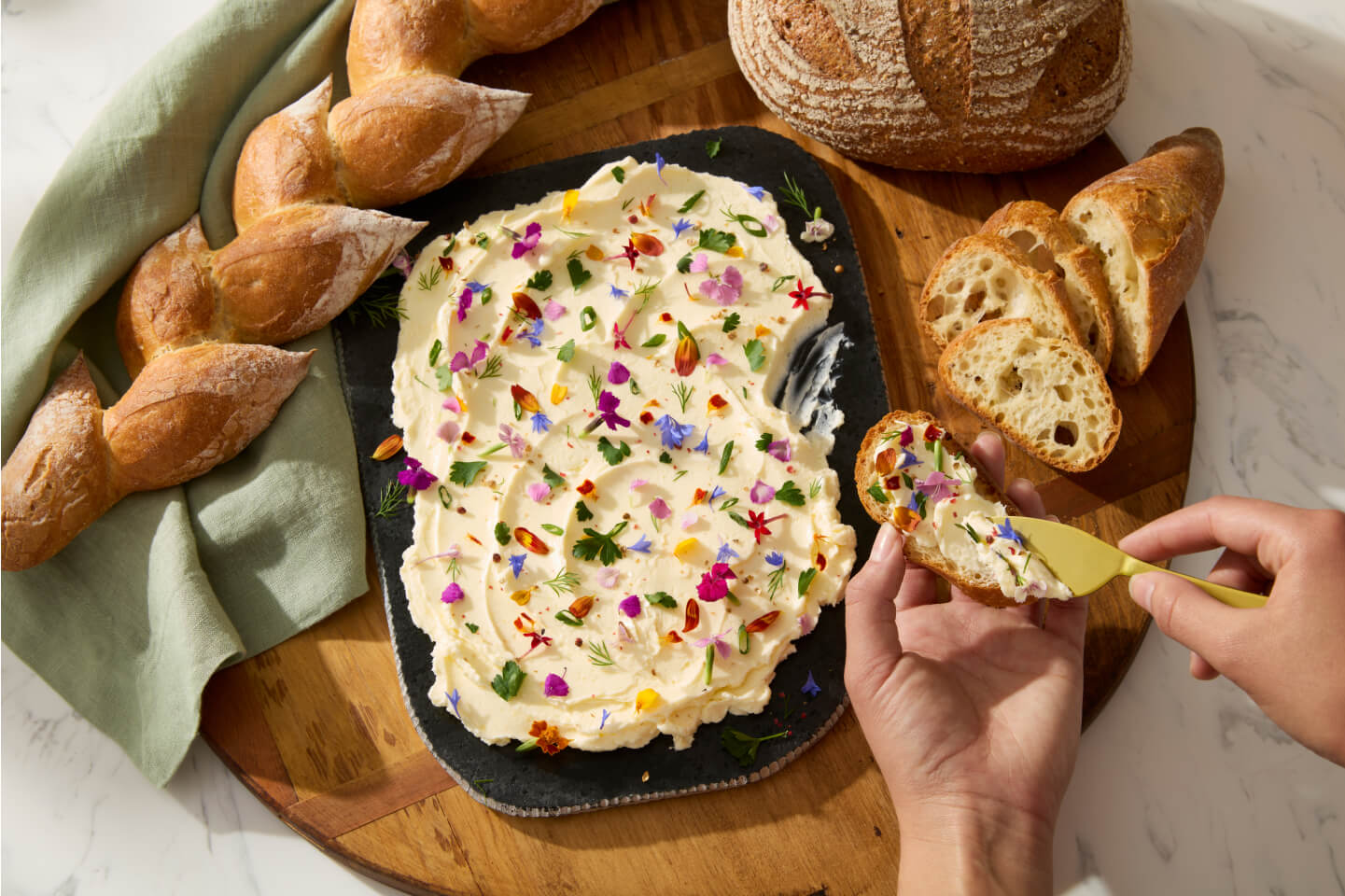 A person spreading butter on crostini.