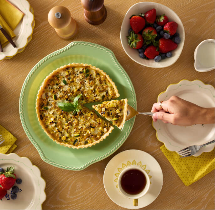 A person serving a wedge of quiche.