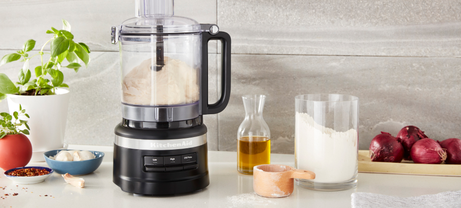 Black KitchenAid® food processor next to baking ingredients