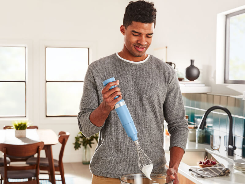 Person using a KitchenAid® cordless hand blender with whisk attachment