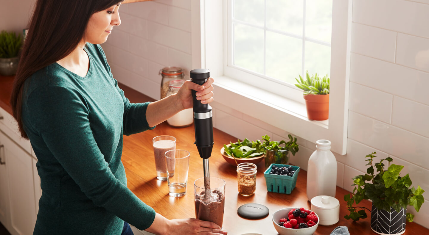 Person using a KitchenAid® cordless hand blender