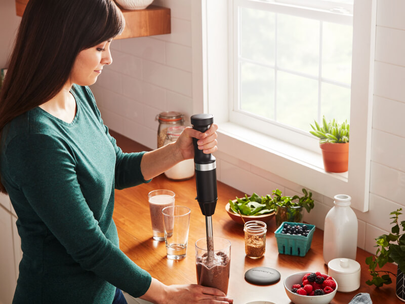 Person using a KitchenAid® cordless hand blender