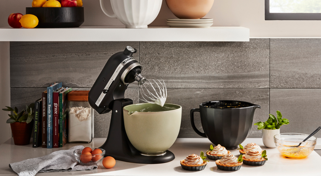 Black KitchenAid® tilt-head stand mixer next to homemade tartes