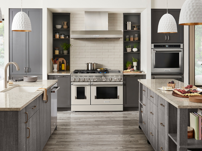Kitchen with two islands, commercial style range and gray cabinets