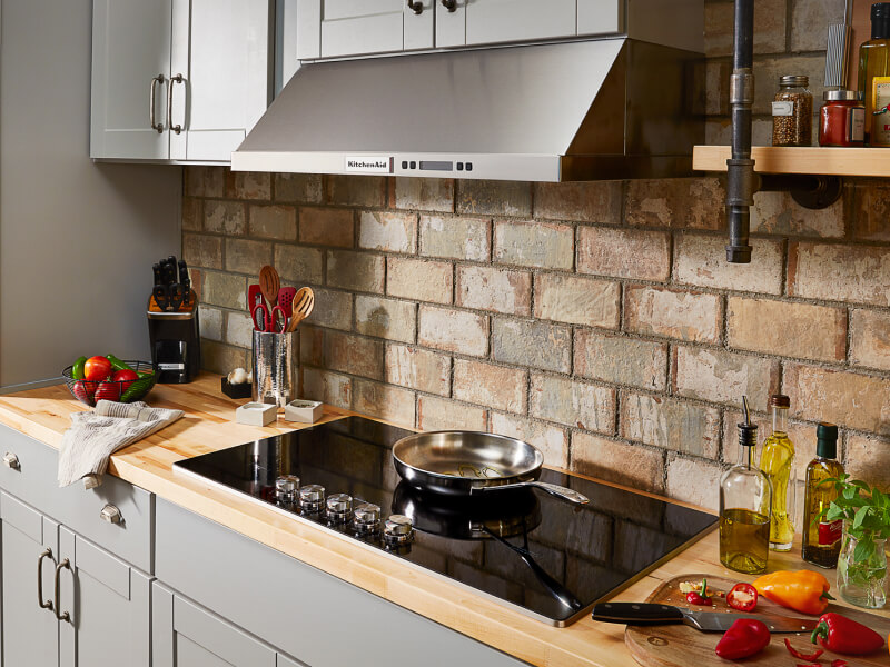 A kitchen with a smooth glass cooktop and wall oven