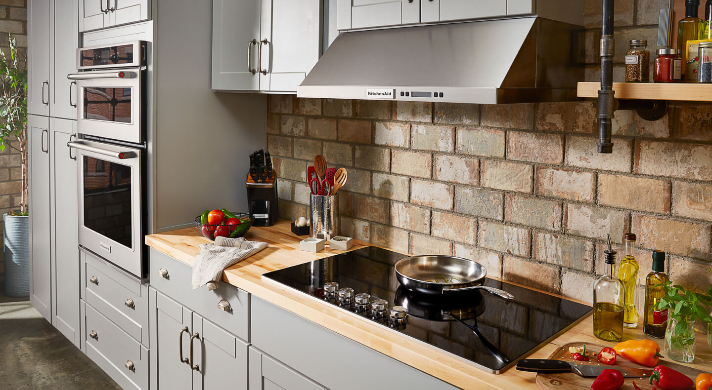 A kitchen with a smooth glass cooktop and wall oven