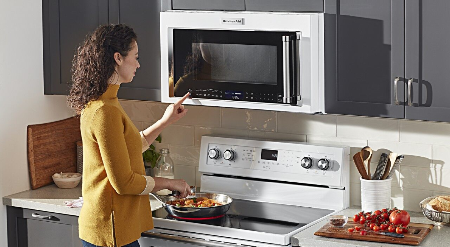 Person selecting a cook setting on a KitchenAid® over-the-range microwave