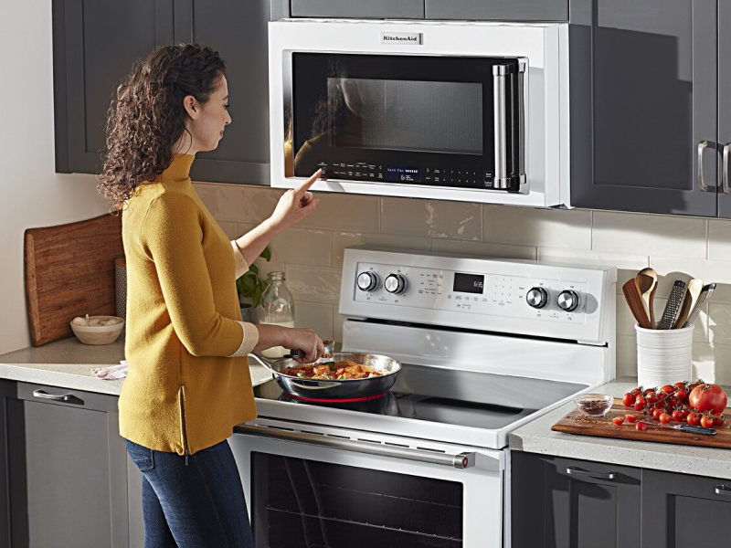 Person selecting a cook setting on a KitchenAid® over-the-range microwave