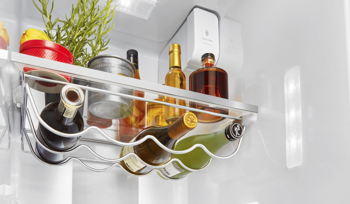 Bottles of wine resting on an interior refrigerator rack