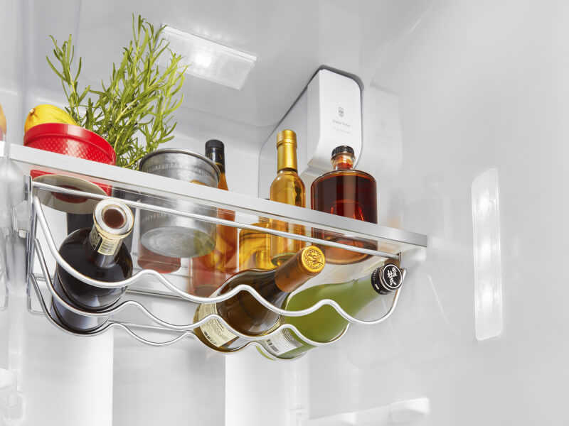 Opened side-by-side refrigerator with a fully-stocked interior