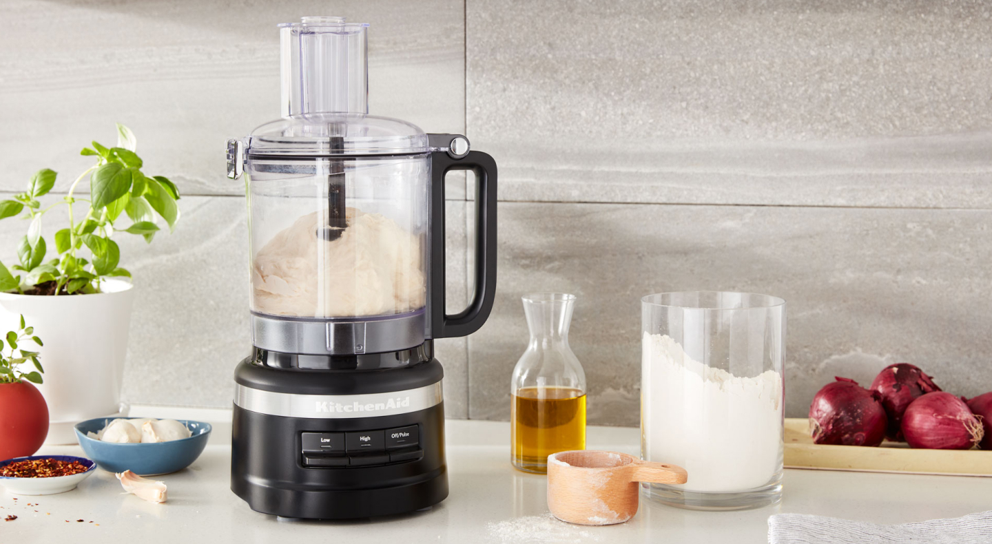 KitchenAid® food processor on counter next to ingredients