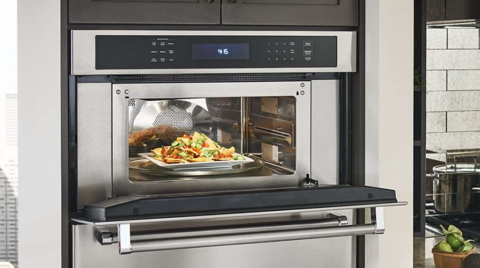 An open KitchenAid® built-in microwave with nachos inside