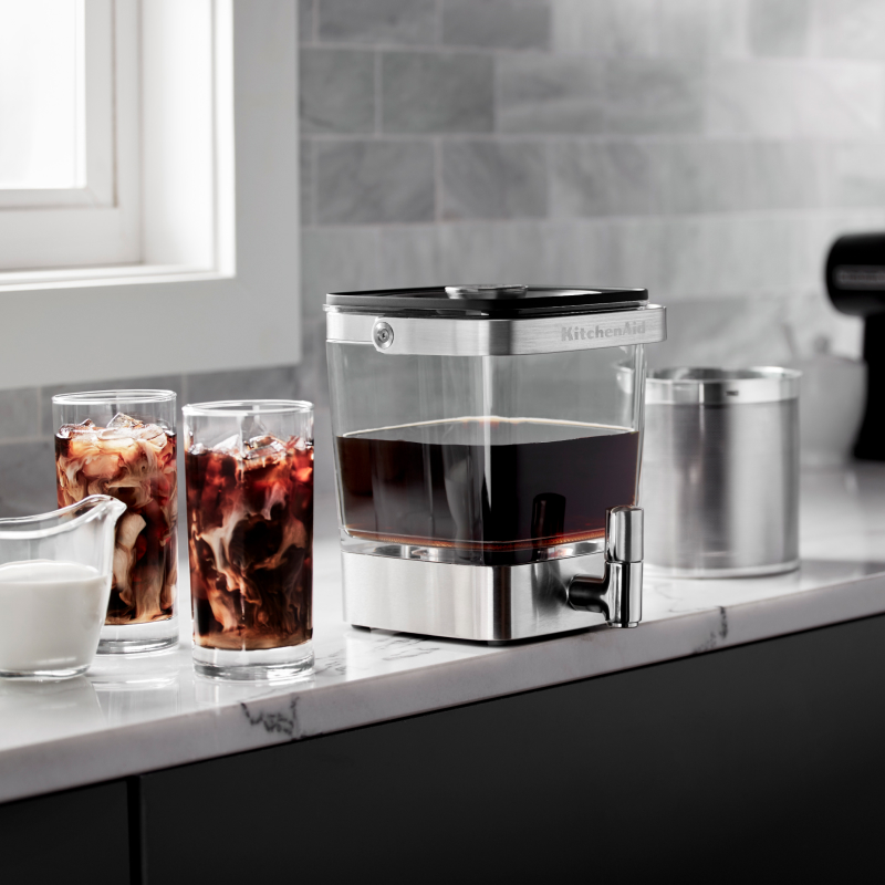KitchenAid® Cold Brew Coffee Maker next to two glasses of cold brew