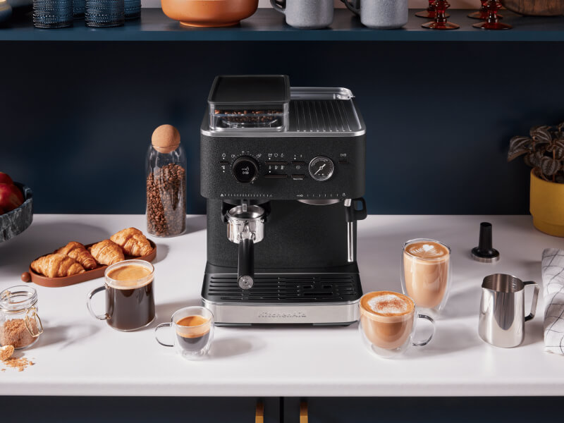 Black KitchenAid® Semi-Automatic Espresso Machine surrounded by espresso drinks