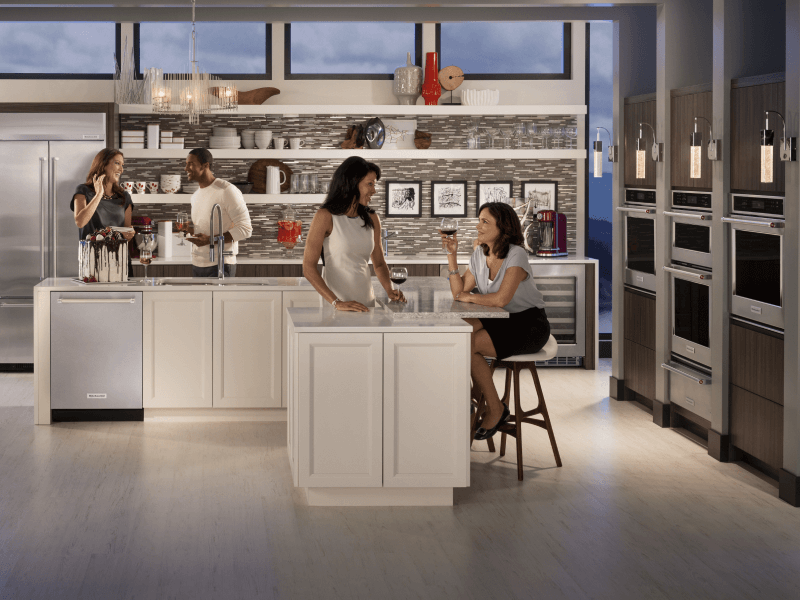 Four people sitting around a kitchen island