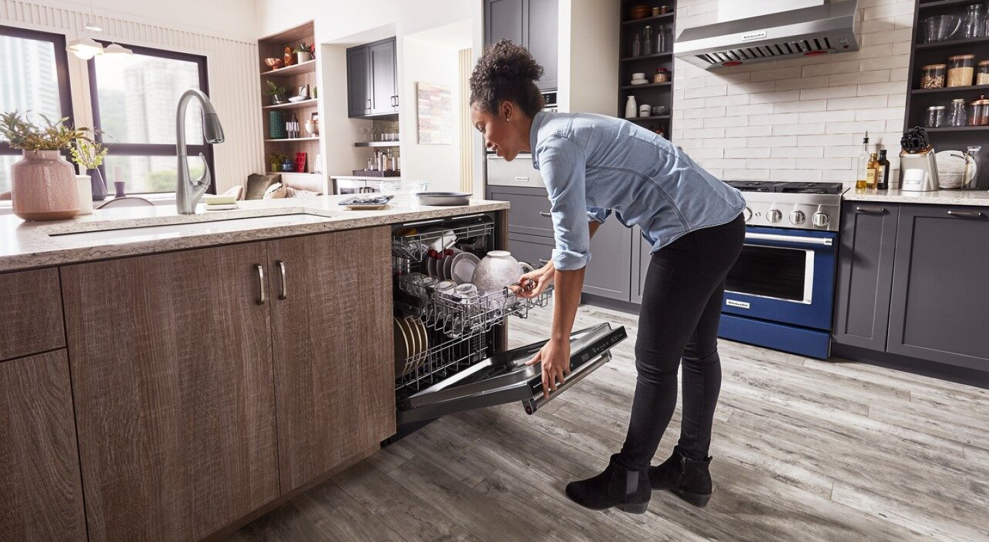 Woman closing a loaded dishwasher