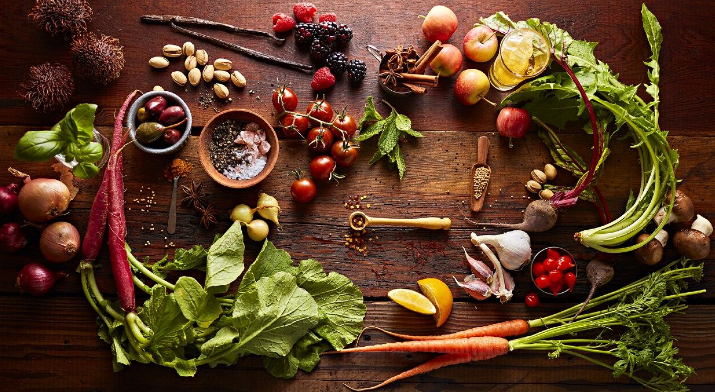 Various vegetables, fruits, herbs and spices on wooden table