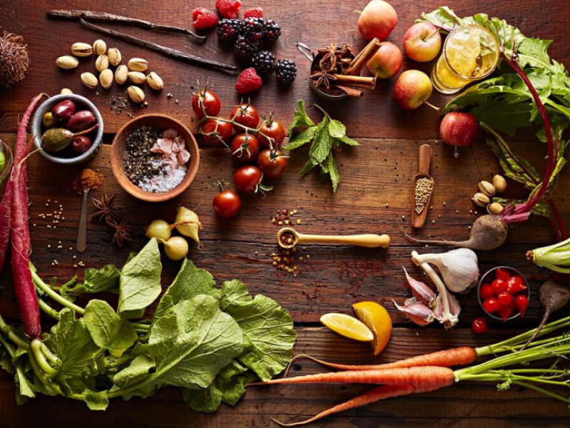 Various vegetables, fruits, herbs and spices on wooden table