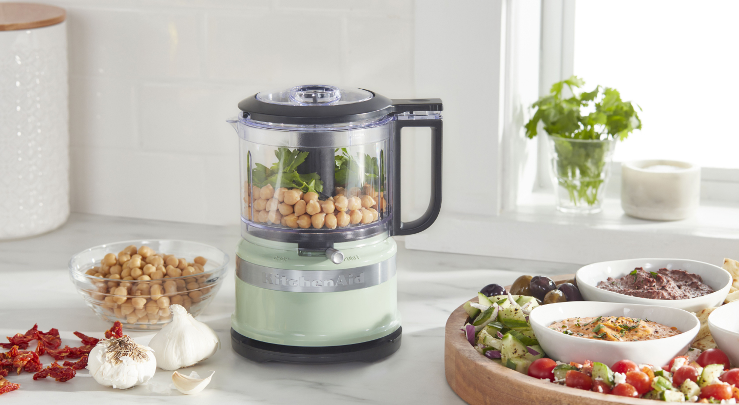 Chickpeas inside a mint green KitchenAid® food processor