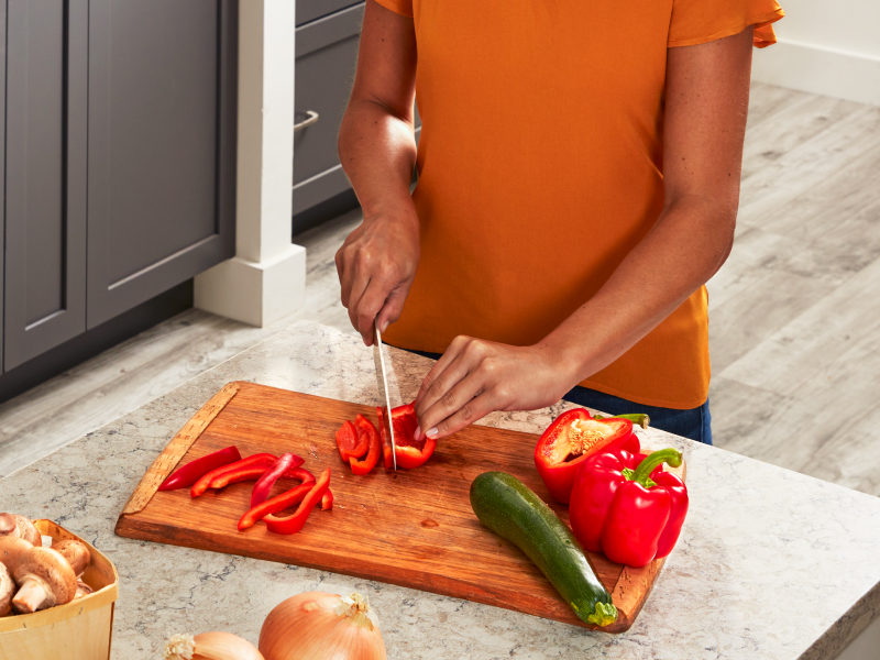 Person slicing bell pepper on a cutting board