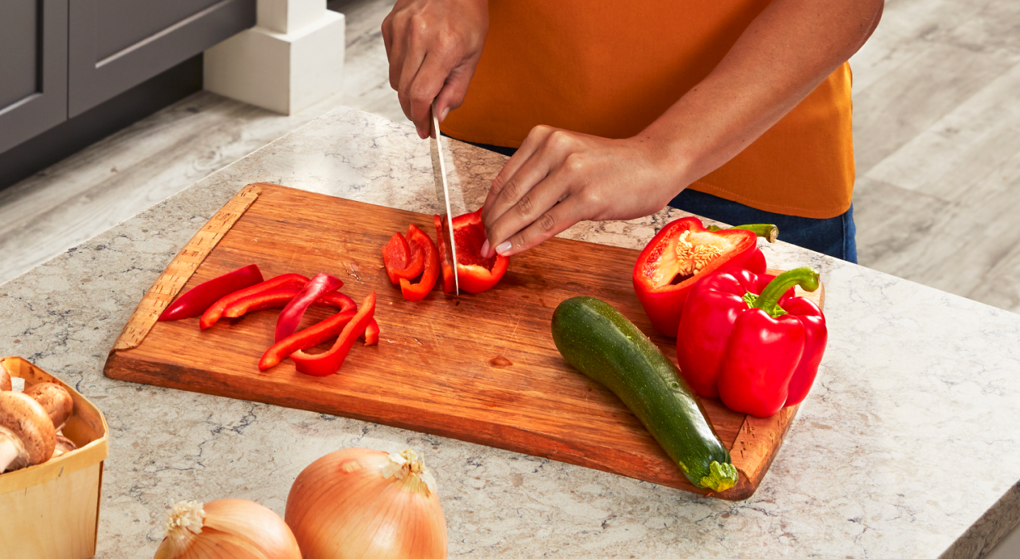 Person slicing bell pepper on a cutting board