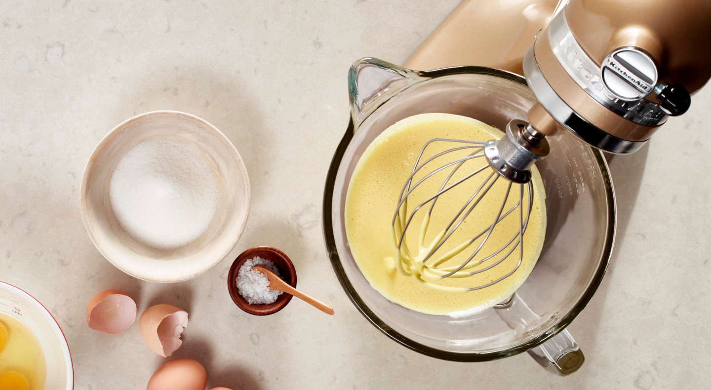 Homemade mayo in a stand mixer next to a bowl of sugar