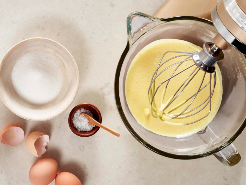 Homemade mayo in a stand mixer next to a bowl of sugar