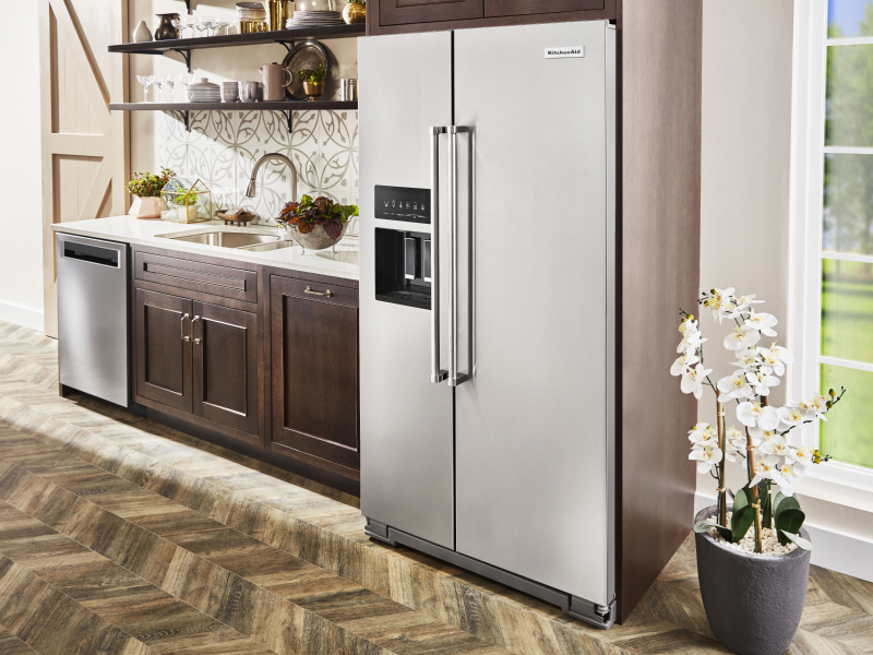 KitchenAid® side-by-side refrigerator in kitchen with brown cabinetry