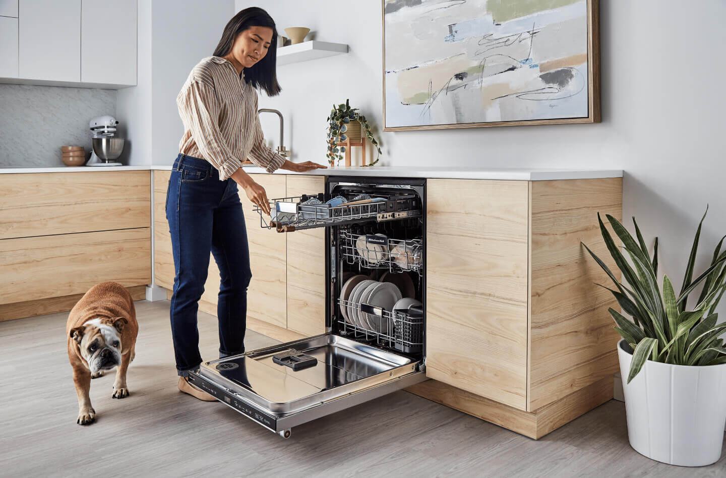 Person loading the third rack of a panel-ready dishwasher 