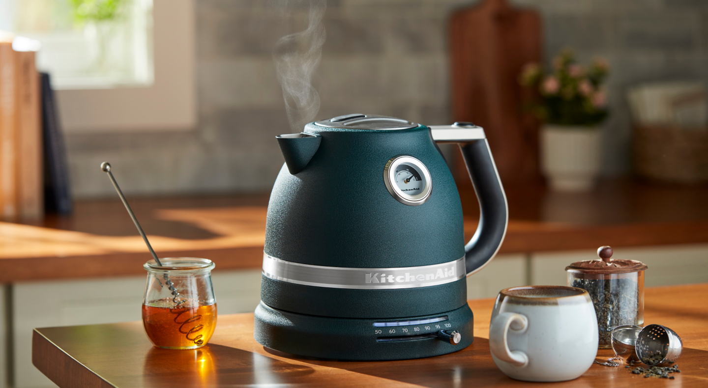 Teal KitchenAid® electric kettle next to tea and honey