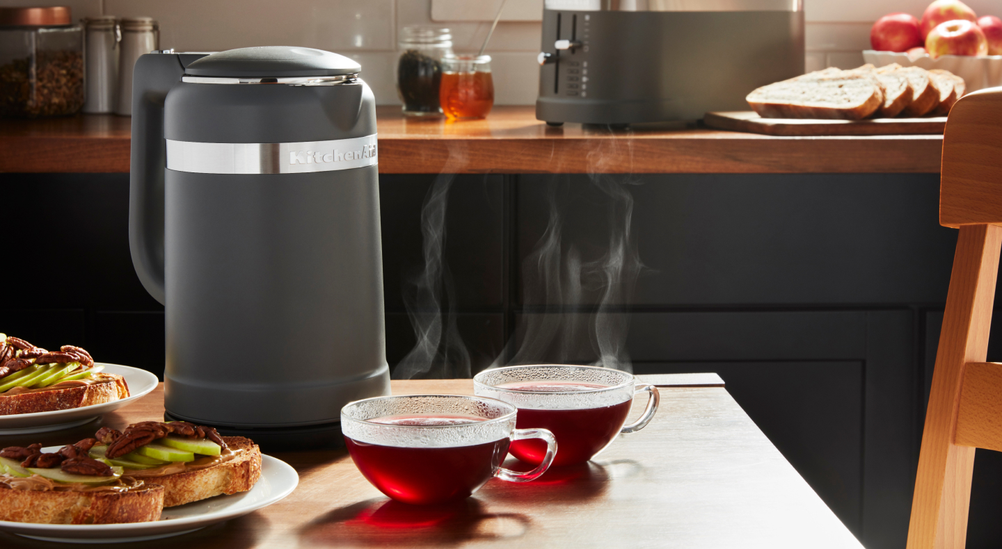 Black KitchenAid® electric kettle next to two glass mugs of tea