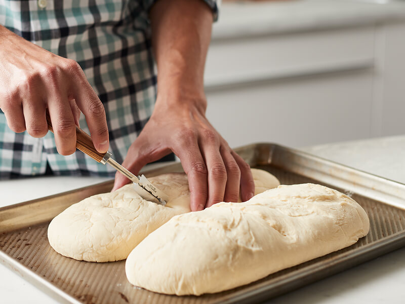 A person scoring dough