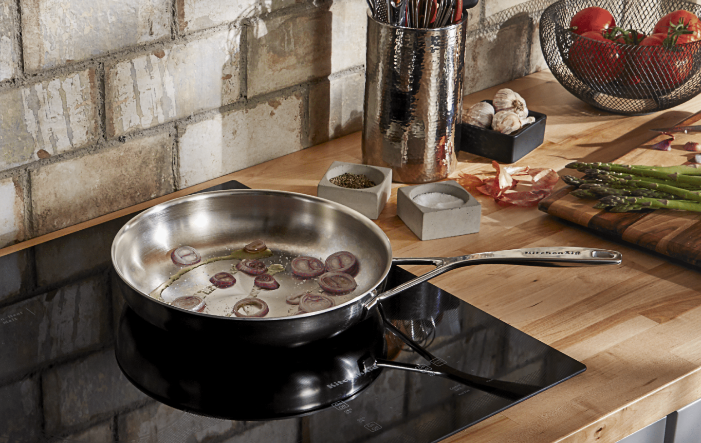 Onions caramelizing on a KitchenAid® cooktop
