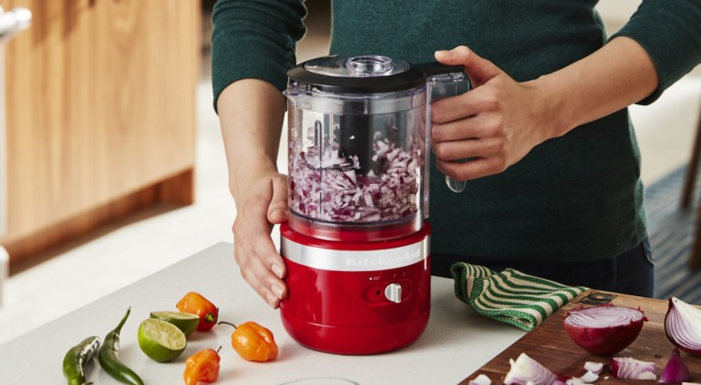  User beginning to chop onions in food processor with additional recipe items in display.