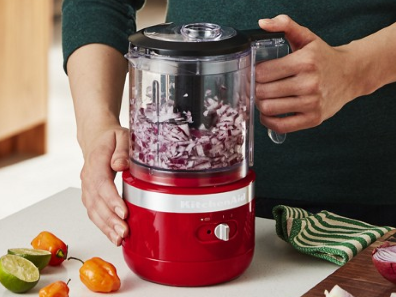  User beginning to chop onions in food processor with additional recipe items in display.