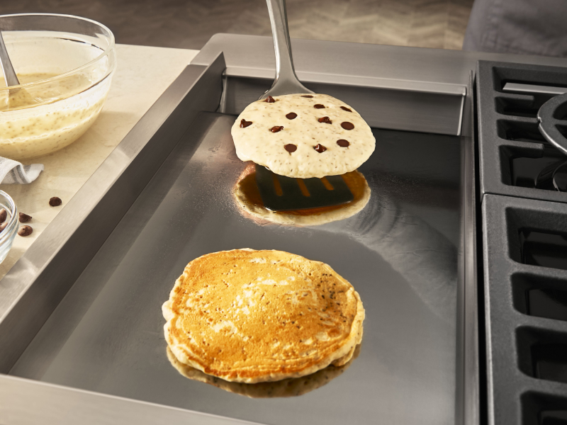 Chocolate chip pancakes on a griddle