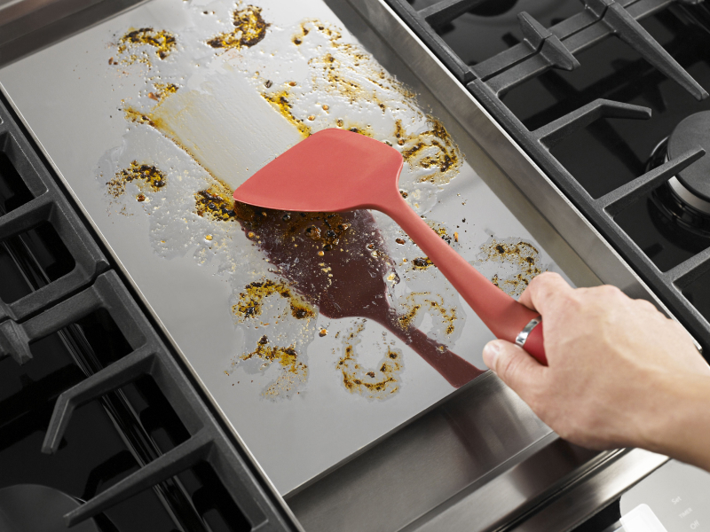 Person spreading grease with a spatula