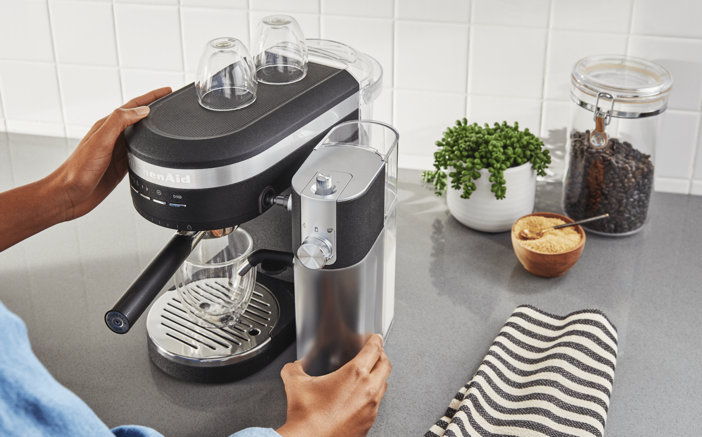 Person removing Automatic Milk Frother Attachment from KitchenAid® Espresso Machine