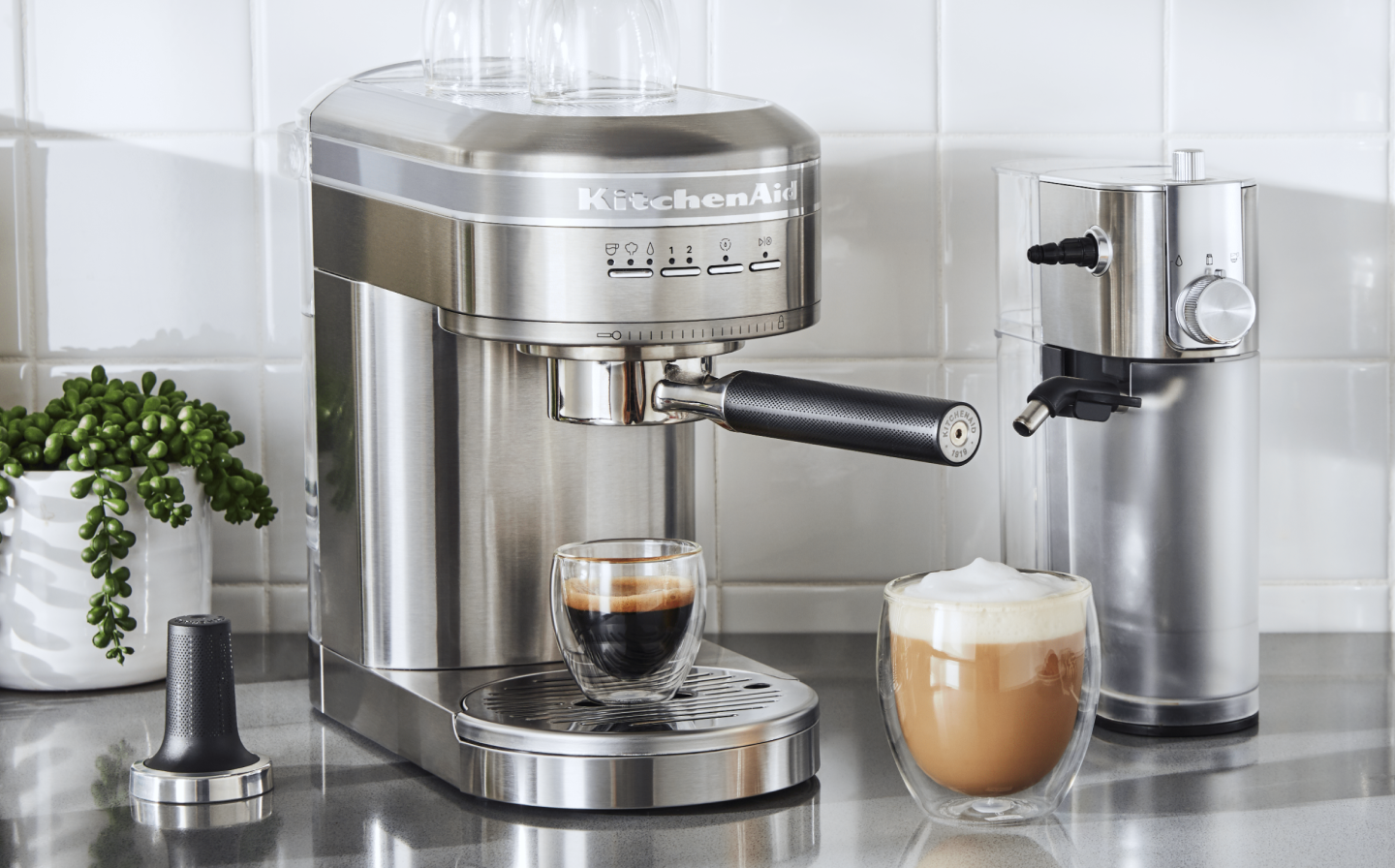 Espresso in a silver KitchenAid® Espresso Machine next to Automatic Milk Frother Attachment