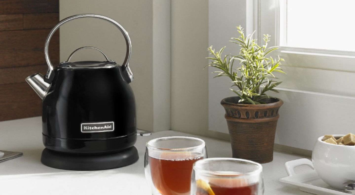 KitchenAid® electric kettle on a kitchen counter next to cups of fresh brewed tea