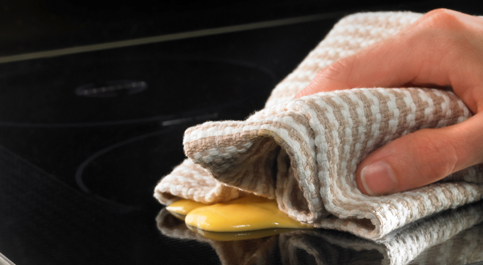 Hand wiping residue off of a cooktop
