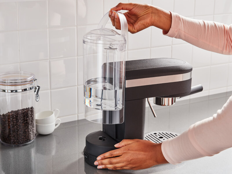 Hand removing the water tank of a KitchenAid® espresso machine