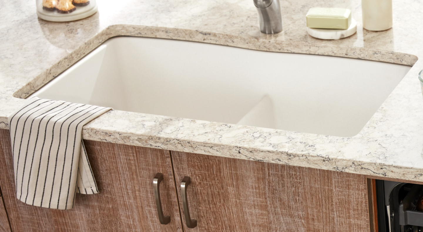 Porcelain sink installed in a white granite countertop