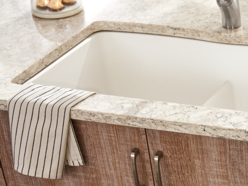 Porcelain sink installed in a white granite countertop