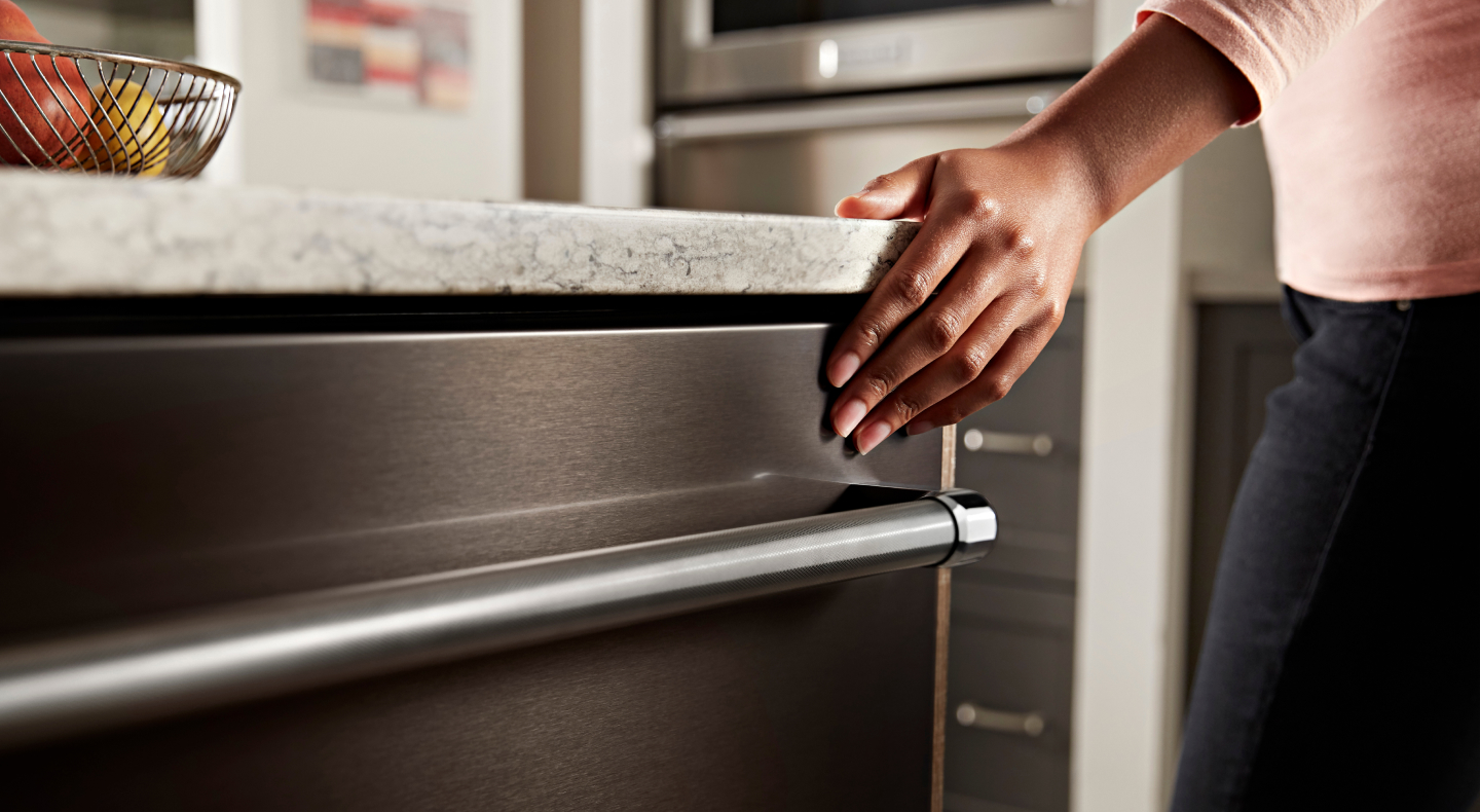 Person closing a dishwasher door