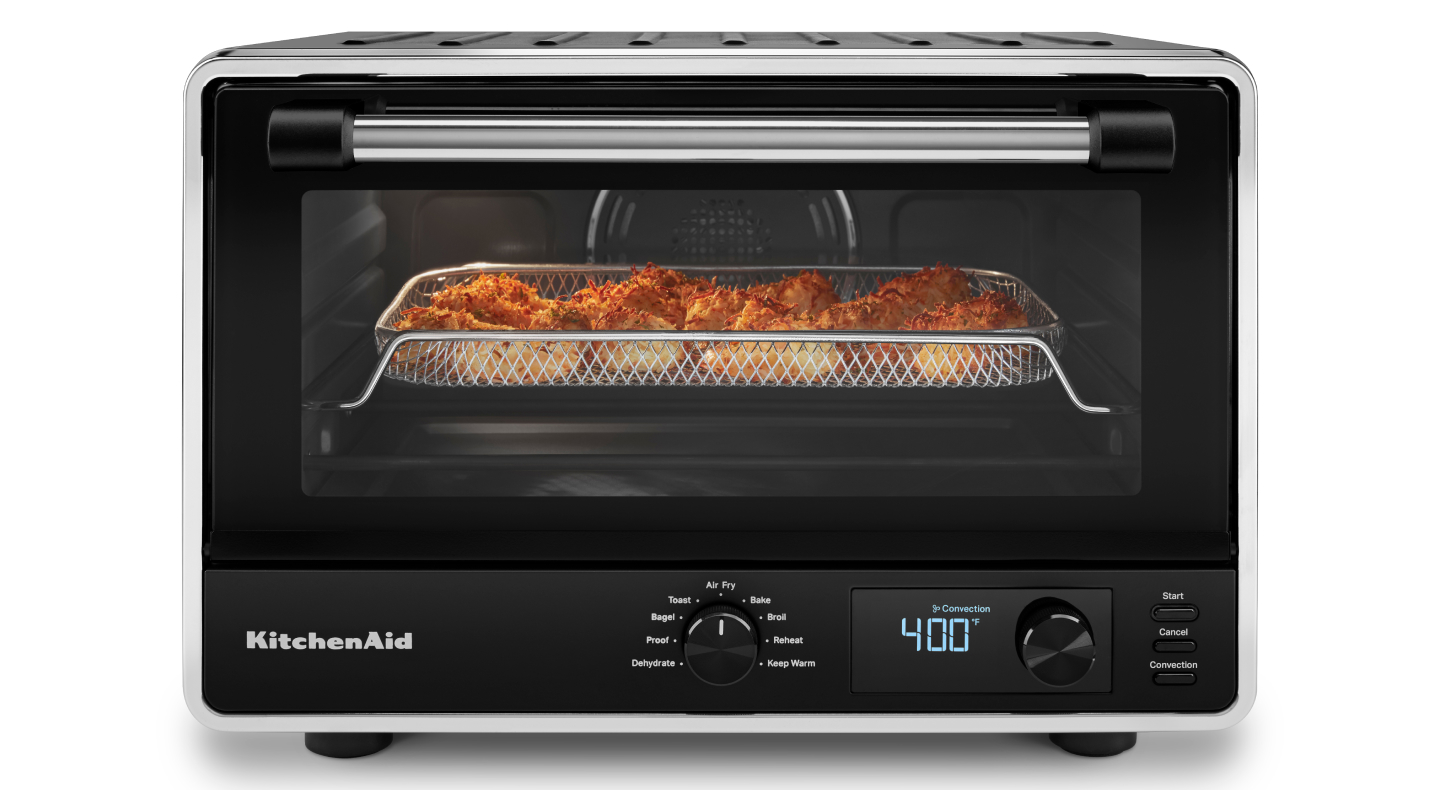 A KitchenAid® countertop oven with a basket of air fryer shrimp.